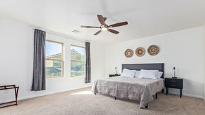 A bedroom with a bed, a nightstand, a ceiling fan, and three wall-mounted decorative plates. - ⭐️ Cozy Vegas Home - Close to Strip - 5 ⭐️ (Las Vegas)