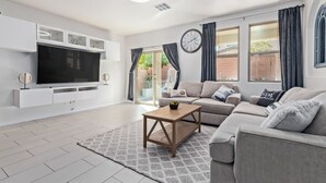 A modern living room with a flat-screen TV, a sofa set, a coffee table, and a patterned rug. - ⭐️ Cozy Vegas Home - Close to Strip - 5 ⭐️ (Las Vegas)
