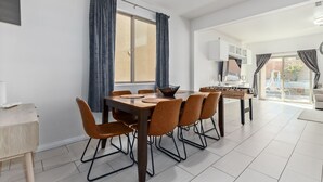 A dining area with a wooden table and six chairs, a window with curtains, and a view of the outside. - ⭐️ Cozy Vegas Home - Close to Strip - 5 ⭐️ (Las Vegas)
