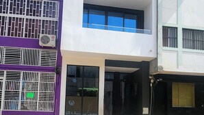 A multi-story building with a flat roof, large windows, and a visible entrance.