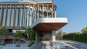 A modern building with a prominent 'AKARA' sign, a spacious entrance area, and a well-maintained garden. - Akara Hotel Pattaya (Pattaya)