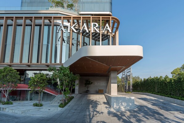 A modern building with a prominent 'AKARA' sign, a spacious entrance area, and a well-maintained garden. - Akara Hotel Pattaya (Pattaya)