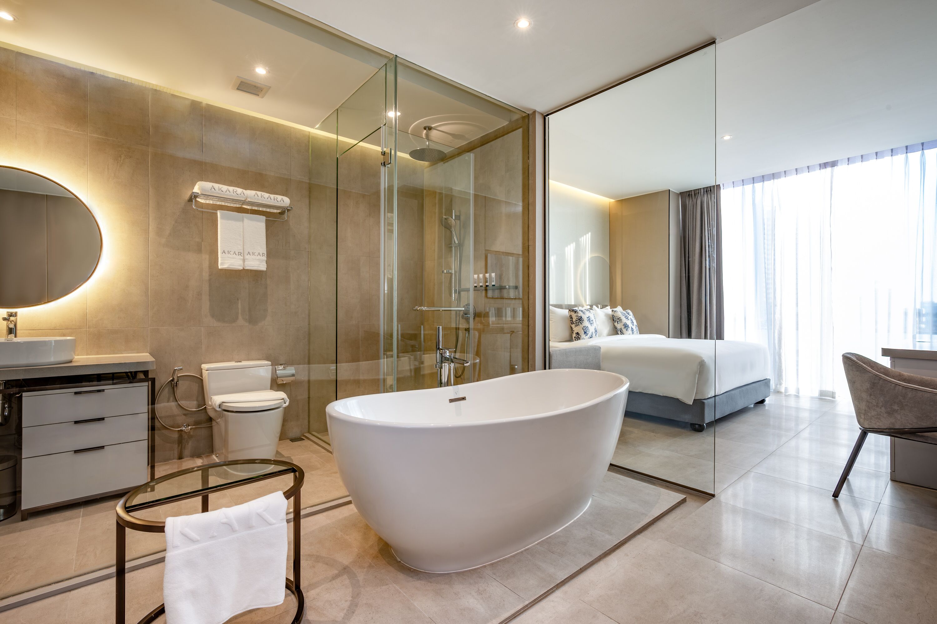 Un baño moderno con una bañera independiente, ducha con mampara de vidrio y un espejo grande.