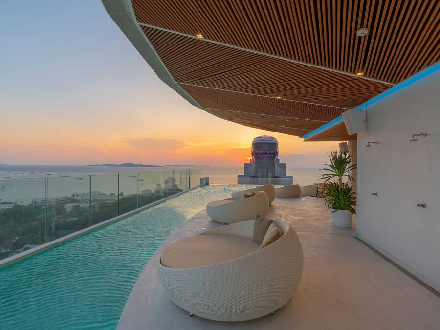 Una piscina en la azotea con vistas a la puesta de sol y un paisaje urbano.
