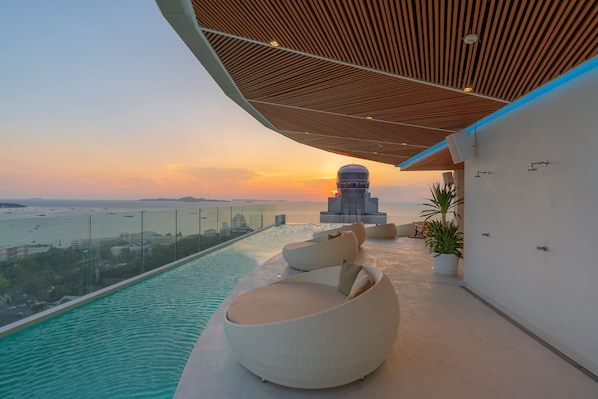 A rooftop pool with a view of the sunset and a cityscape. - Akara Hotel Pattaya (Pattaya)