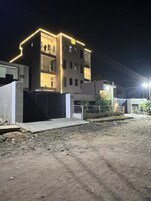 Un edificio moderno con tejado plano, varias ventanas y un cartel que indica que es un hotel.