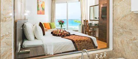 Una habitación de hotel moderna con una cama grande, una bañera y vista al mar.