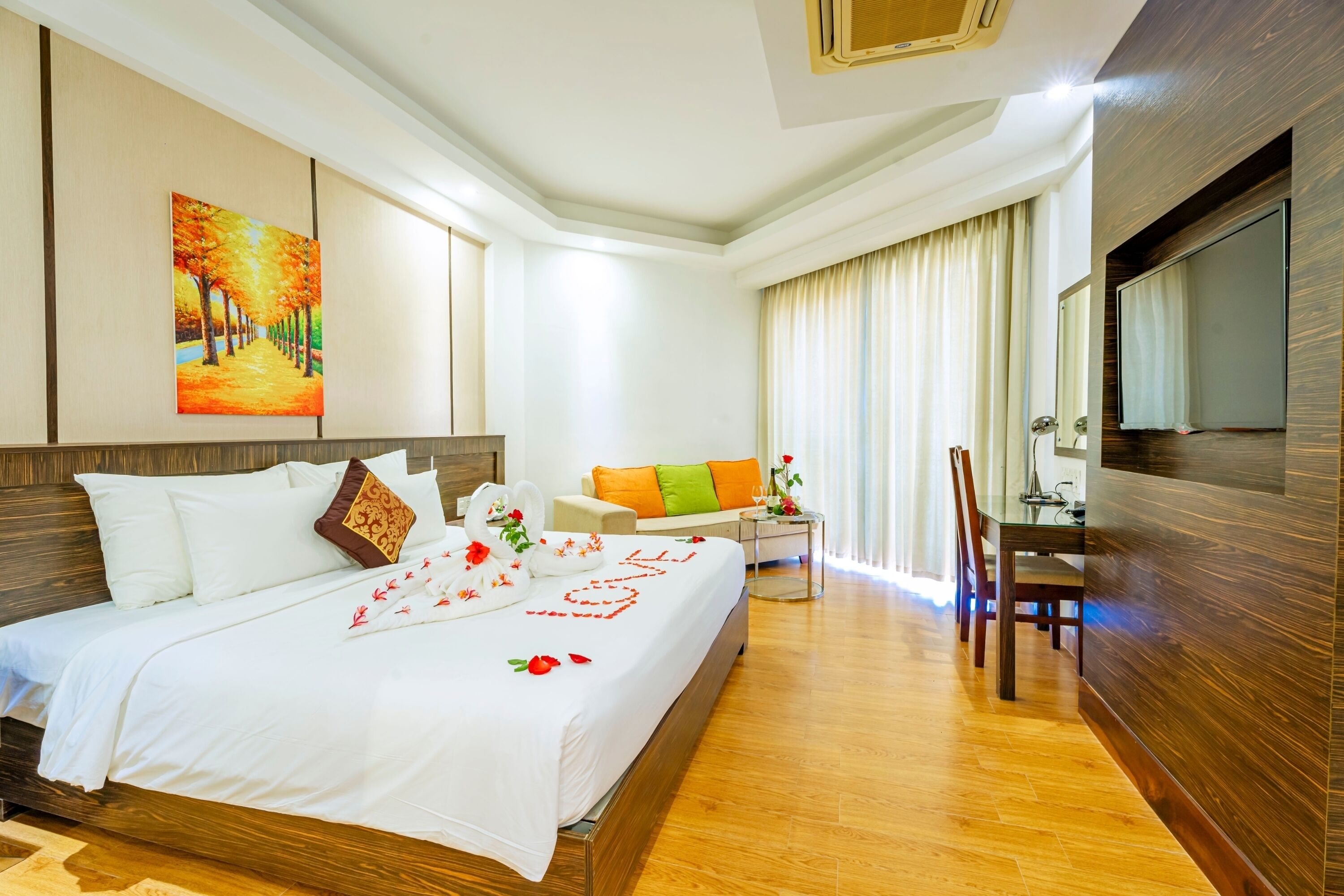 Una habitación de hotel con cama, sofá, escritorio y televisión.