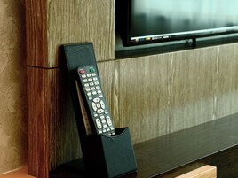 Un control remoto en un estuche de cuero sobre una superficie de madera.