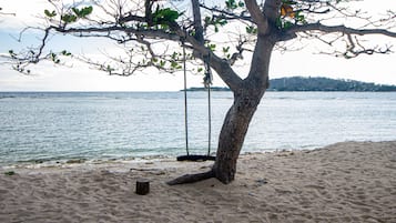 På stranden, hvit sand, solsenger og parasoller