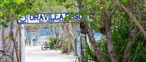 A sign for Oravilla Beach with a bicycle parked nearby.
