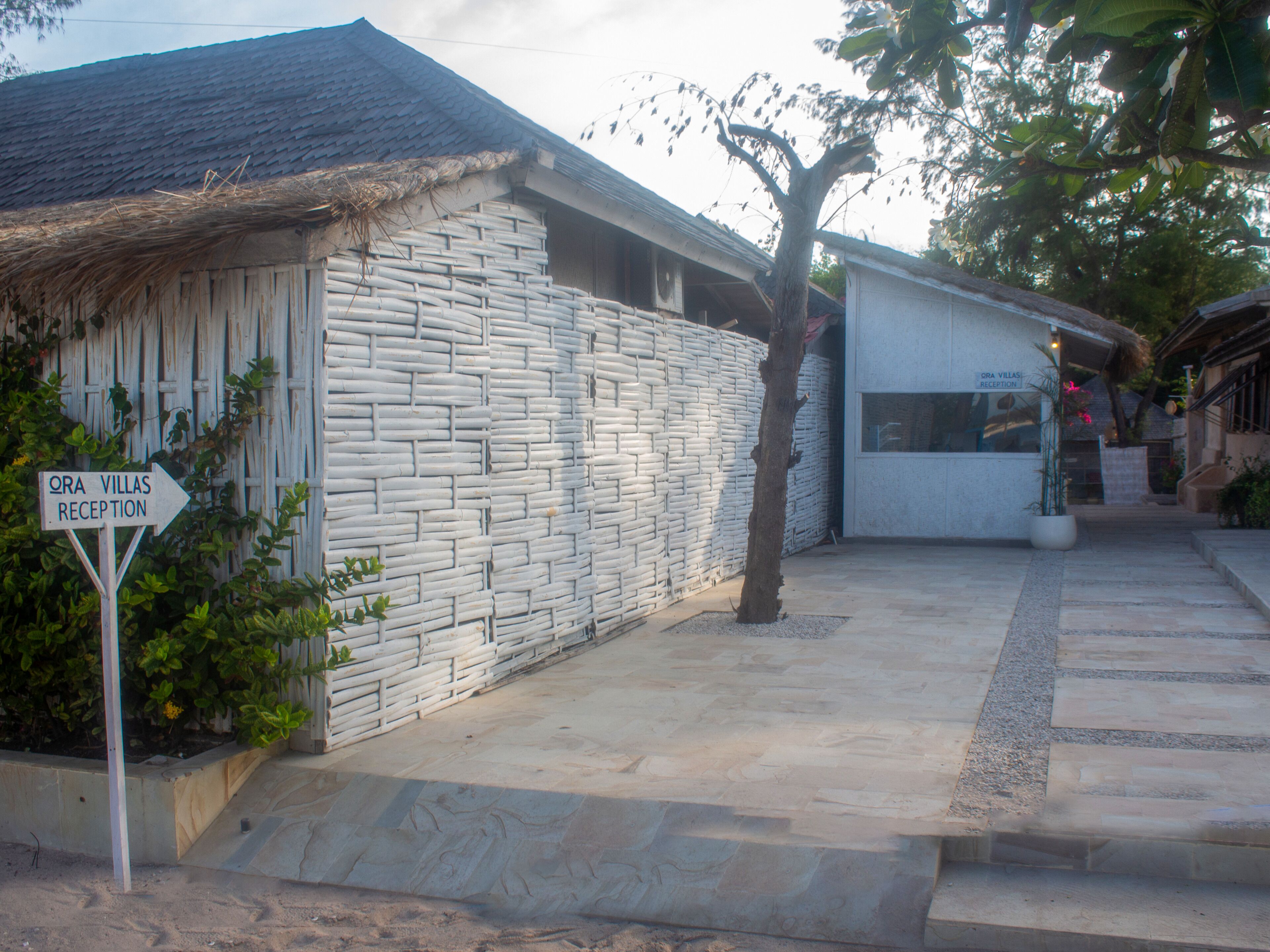 A reception area with a stone wall and a thatched roof.