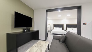A modern hotel room with a flat-screen TV, a sofa, a marble coffee table, and two beds with black headboards. - Busan Seomyeon Broa Hotel (Busan)