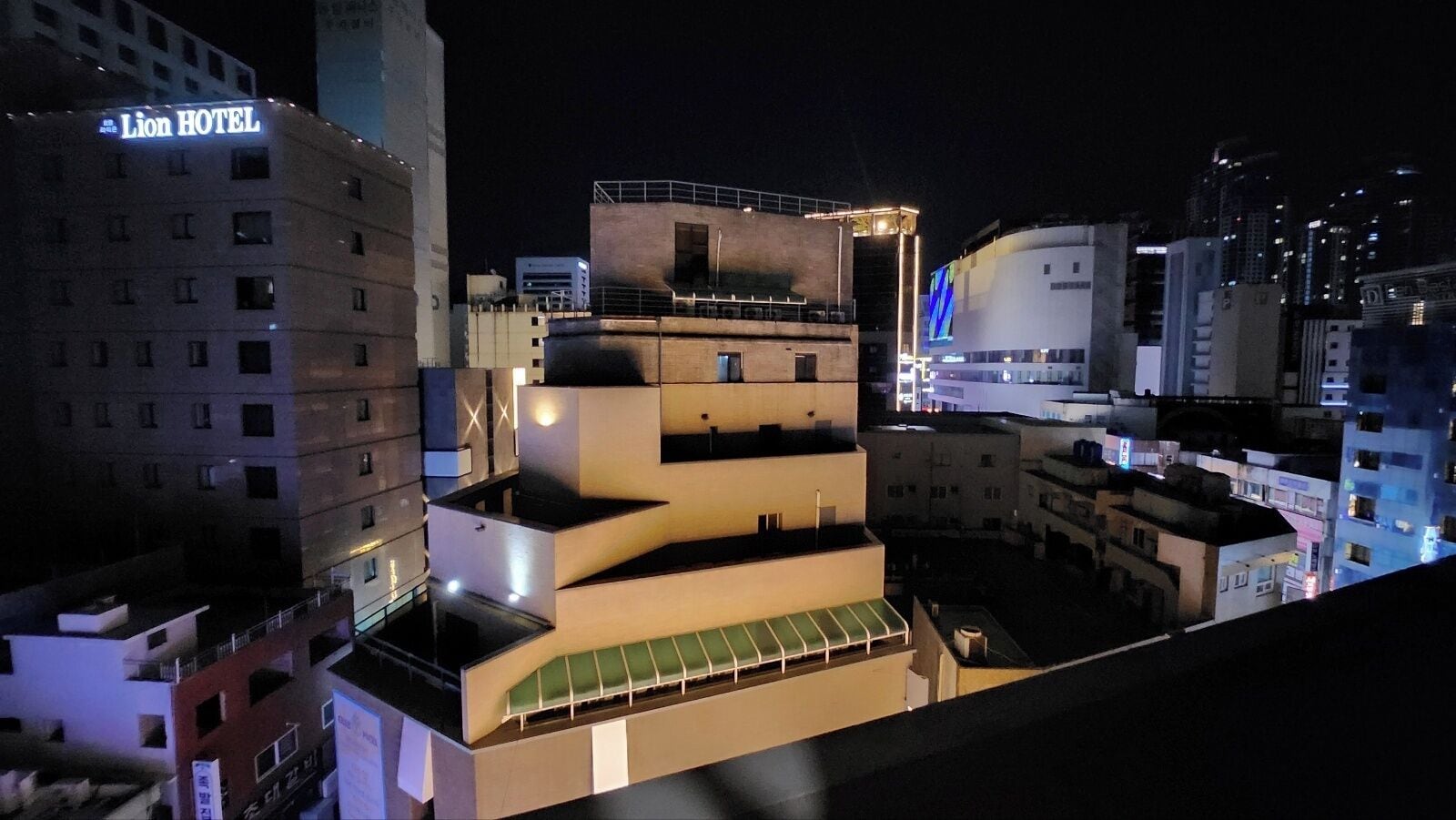 Un edificio de varios pisos con un llamativo letrero que dice 'Lion Hotel', rodeado de otros edificios.