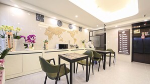 A hotel reception area with a world map, clocks, a coffee machine, and a menu board. - Busan Seomyeon Broa Hotel (Busan)