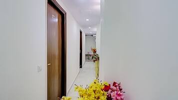 A hallway with wooden doors and a vase of flowers.