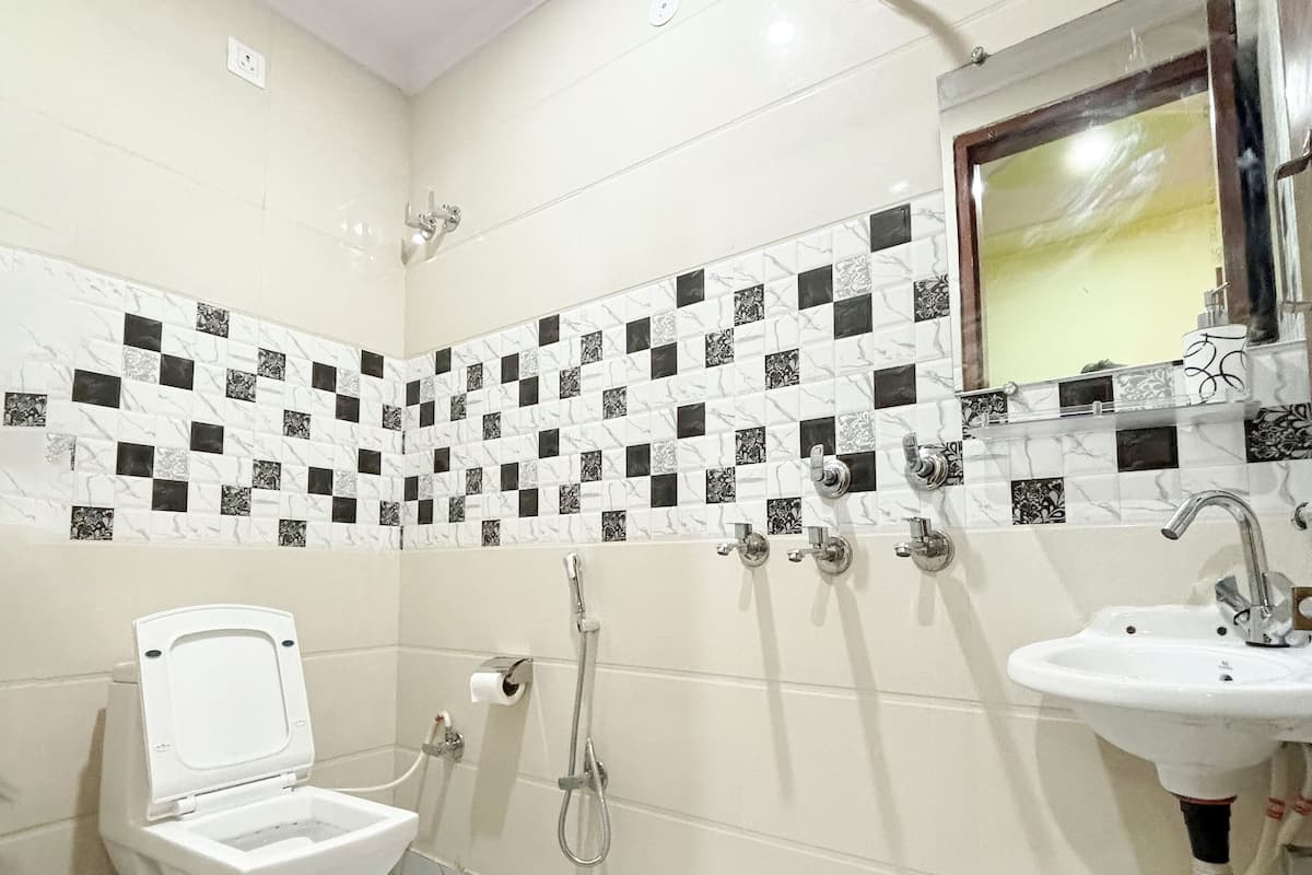 A bathroom with a toilet, a sink, and a shower.