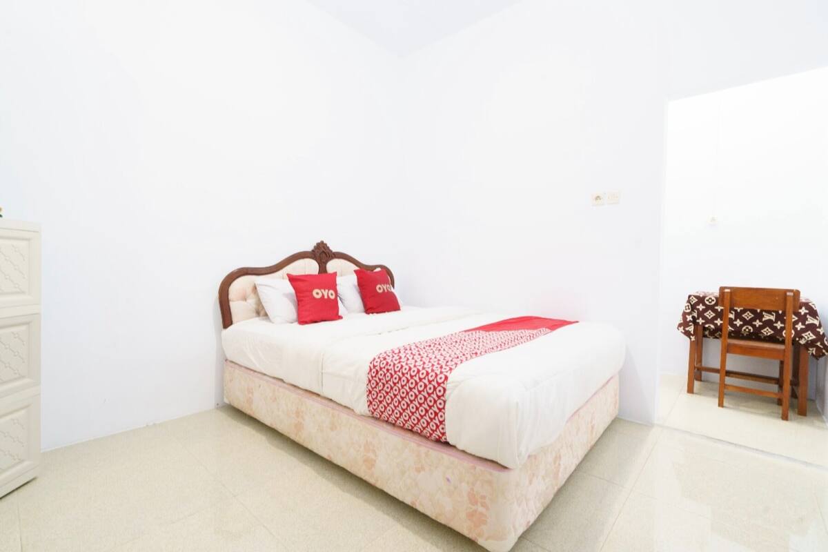 A neatly arranged bedroom with a bed, a chair, and a dresser.
