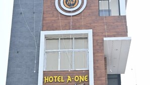 A building with a sign reading "HOTEL A-ONE" and a logo with a circular design. - Hotel A One Luxury (Puri)