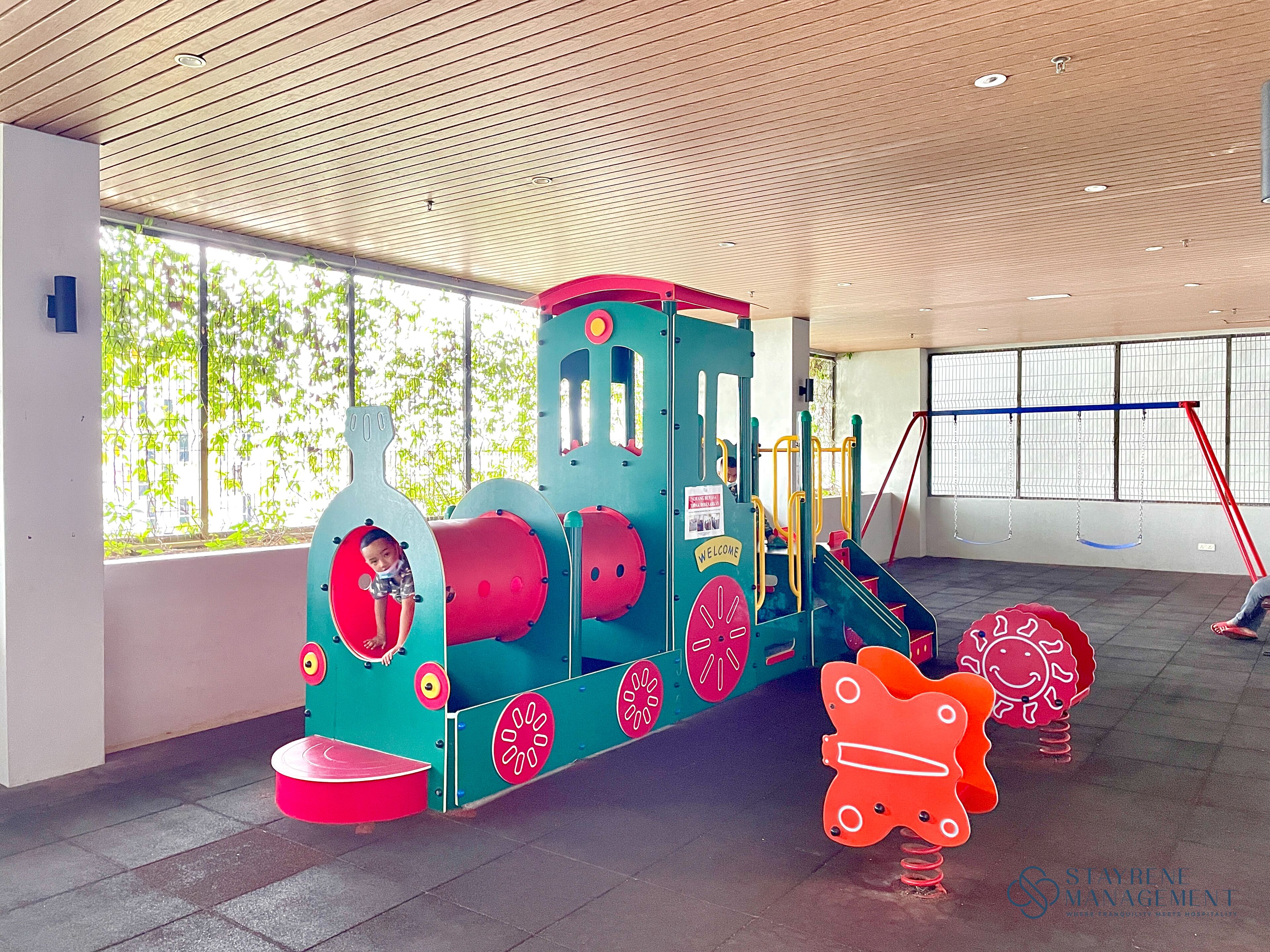 A children's play area with a colorful train set and a swing.