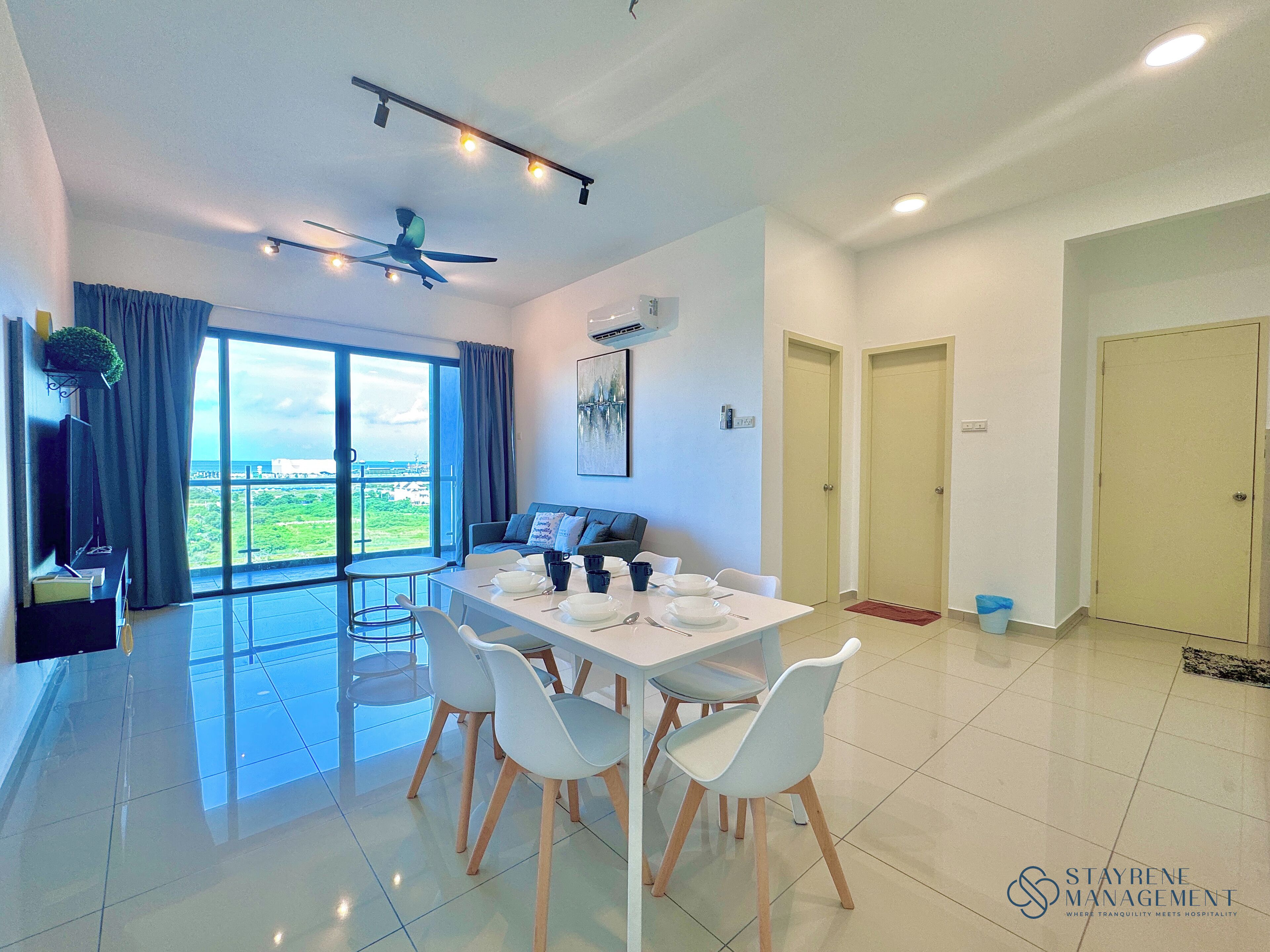 A modern dining area with a table set for four, a ceiling fan, and a large window offering a view of the outdoors.
