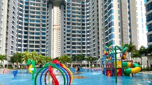 A swimming pool area with colorful water slides and a high-rise building in the background. - Atlantis Residences Melaka by Stayrene (Malacca City)