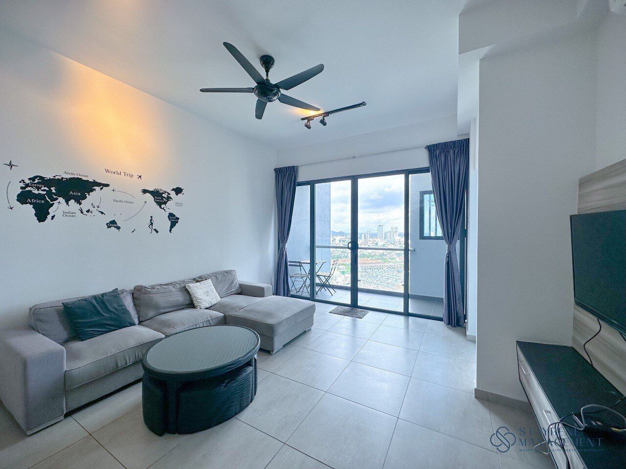 A modern living room with a sofa, coffee table, and a world map on the wall.