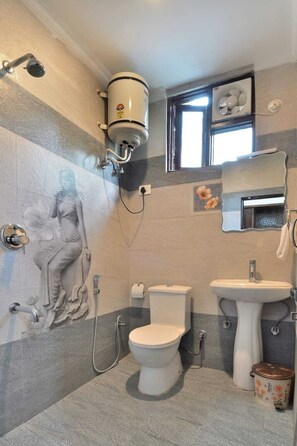 Bathroom features a toilet, bidet, and sink, with a decorative mural and a window above the sink.