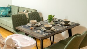 A dining table set with bowls and plates, a glass, and a plant. - Stunning 3BD Flat, Parking, Sleeps Six, Near Park (London)