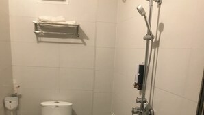 A bathroom with a toilet, a shower, and a bathtub.