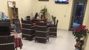 A reception area with a TV, a plant, and a Christmas tree.