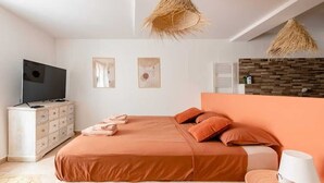 A bedroom with a bed, a TV, a dresser, and a wall-mounted heater. - Casa Relax Appart Cocooning Dans Village Provençal (Montfort-sur-Argens)
