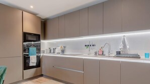 A modern kitchen with built-in appliances, a countertop with various items, and a sleek design. - Elegant & Serene 2BD Flat W/roof Terrace Hoxton! (London)