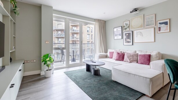 A modern living room with a sofa, a coffee table, and a potted plant. - Elegant & Serene 2BD Flat W/roof Terrace Hoxton! (London)