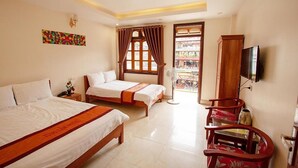 A hotel room with two beds, a TV, a fan, and a view of a building outside. - Tung Lam Hotel Sapa - by Bay Luxury (Sa Pa)