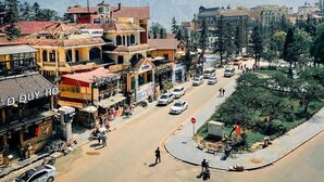 A street view with shops, a roundabout, and a park area. - Tung Lam Hotel Sapa - by Bay Luxury (Sa Pa)