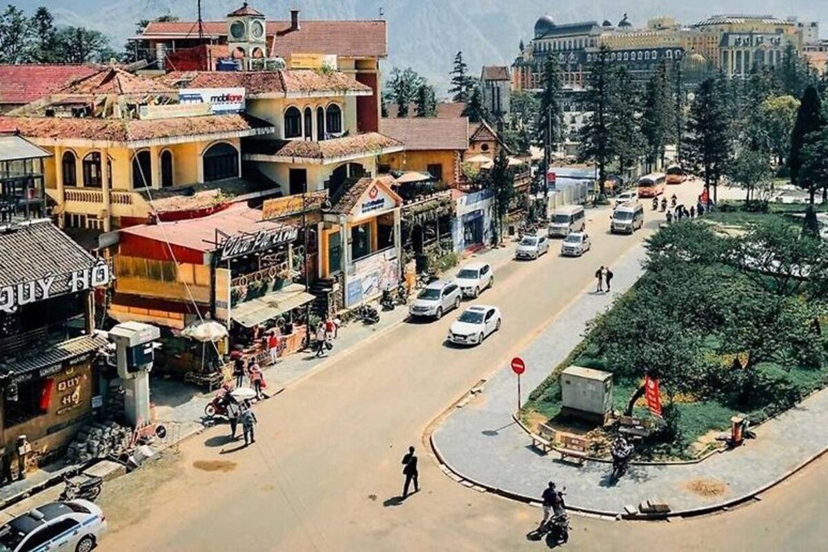 A street view with shops, a roundabout, and a park area.