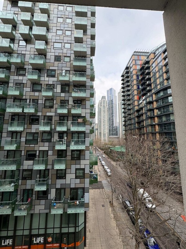 A high-rise building with a modern design, featuring a grid of balconies and a glass facade.