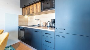 A modern kitchen with a microwave, coffee maker, and built-in oven. - Apartment Babic (Vir)
