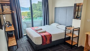 A hotel room with a bed, a desk, a chair, and a view of the outdoors. - Pangkor Pop Ash Hotel (Pangkor Island)