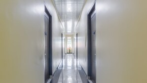 A long, narrow hallway with a shiny floor and doors on both sides. - OYO Life 3365 Griya Nusantara Syariah (Bandar Lampung)