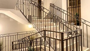 A multi-level staircase with ornate metal railings and a white interior.