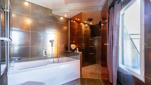 A modern bathroom with a large bathtub, a shower area, and a glass-enclosed shower. - Sublim by Sweet Inn Paris (Paris)