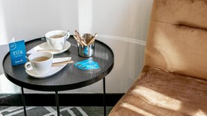 A small round table with two white cups of tea, a tray, and a metal cup holder with tea spoons. - Sublim by Sweet Inn Paris (Paris)
