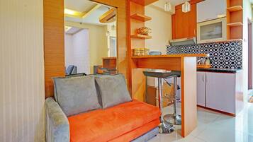 A compact living space with a sofa, kitchenette, and a dining area.