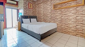 A bedroom with a bed, a water dispenser, and a wall-mounted air conditioner. - OYO Life 92993 Apartement Gateway Cicadas By Mgm Property (Bandung)