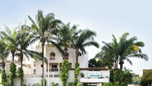 A hotel with a white facade, multiple balconies, and a green gate. - Residence Hotel Edouard (Abidjan)