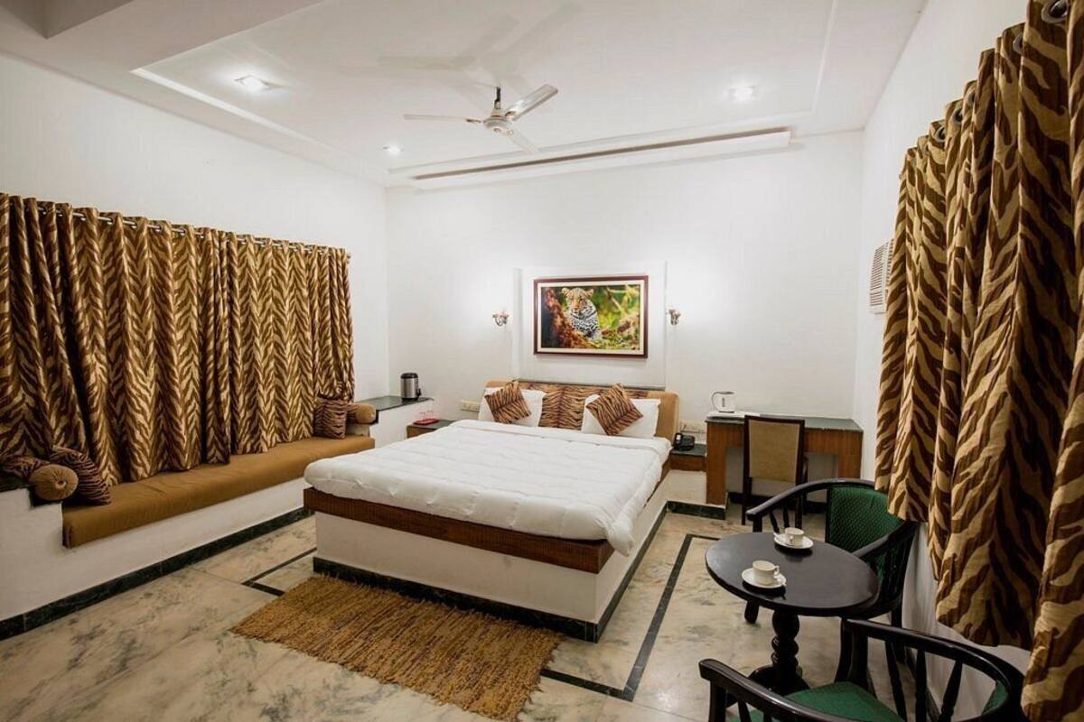 A hotel room with a bed, a sofa, a small table, and a chair.
