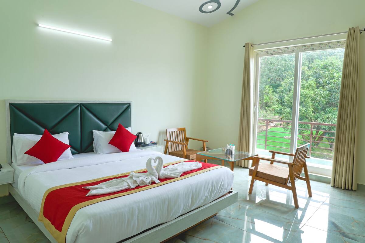 A hotel room with a bed, a table, and chairs.