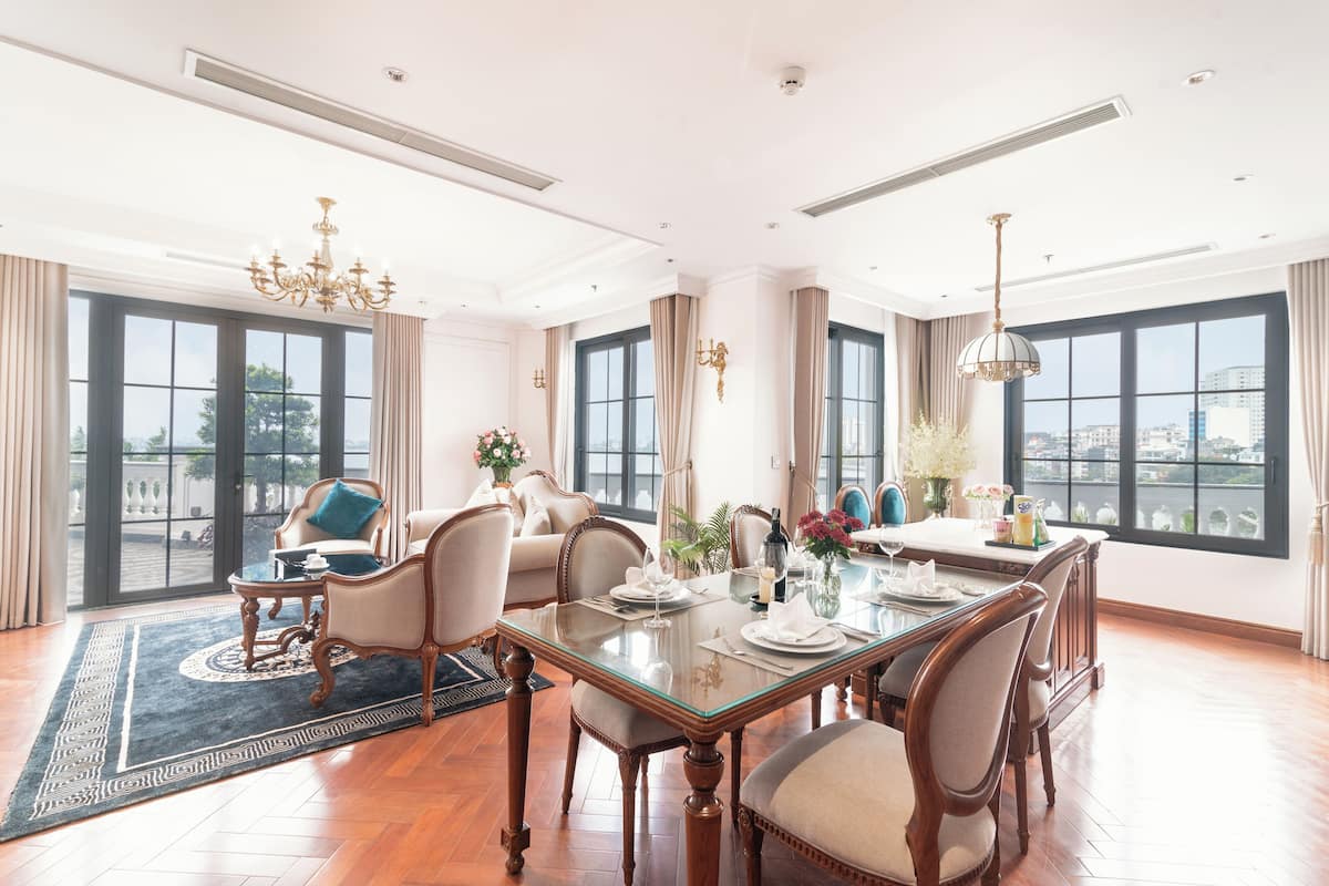 Un vaste espace dédié à la salle à manger, avec une grande table dressée pour six personnes, entourée de chaises confortables.